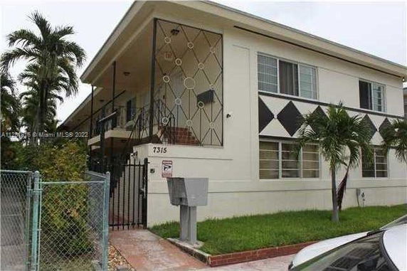 Front view of a two-story building with decorative railing and a gated entrance.