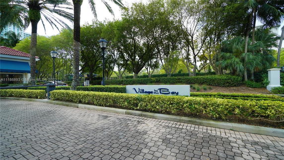 Entrance view of a residential area with a sign reading 'Village at the Bay'.