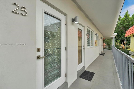 Exterior corridor of a building with multiple doors leading to individual units.
