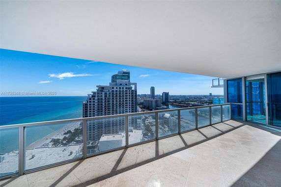 View from a balcony showing high-rise buildings and the ocean.