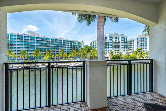 View from a balcony overlooking a river and modern buildings.