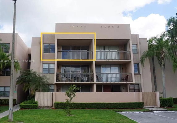Front view of a multi-story apartment building with balconies.