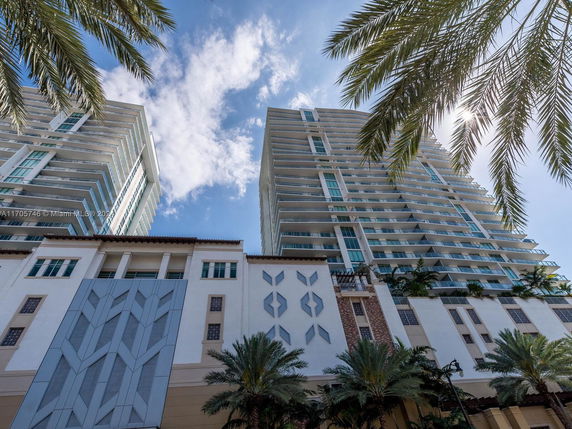 Front view of a modern high-rise building with multiple balconies and geometric patterns.