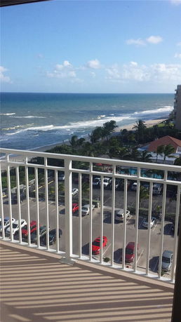 View from a high balcony overlooking the ocean and surrounding beach area.