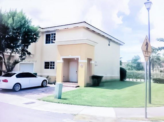 Front view of a two-story house with a single car parked in the driveway.