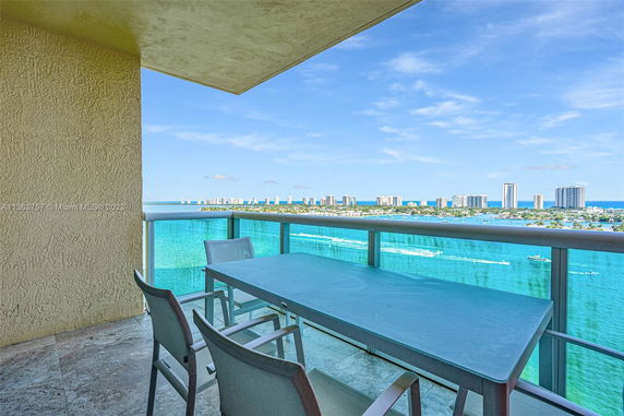 Panoramic view from a balcony showing a body of water and distant city skyline.