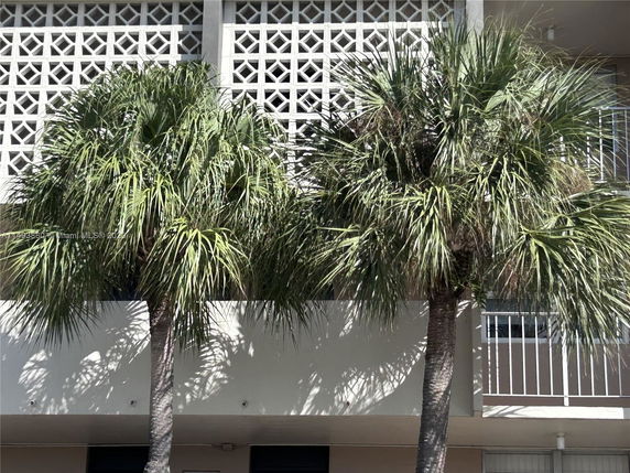 Front view of a building with decorative lattice wall design and balcony railings.