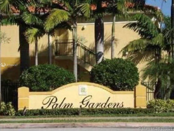 Front view of a building labeled Palm Gardens surrounded by palm trees.