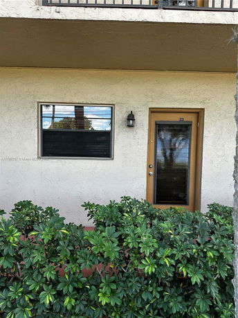 Front view of a two-story building with a window and door on the ground floor.