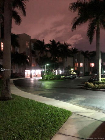 Front view of a multi-story building at night with illuminated entrance.