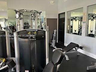 Indoor gym area with exercise equipment and mirrors.