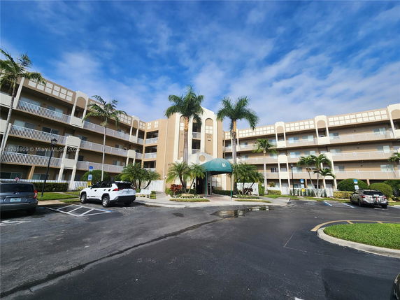 Front view of a multi-story apartment building with balconies.