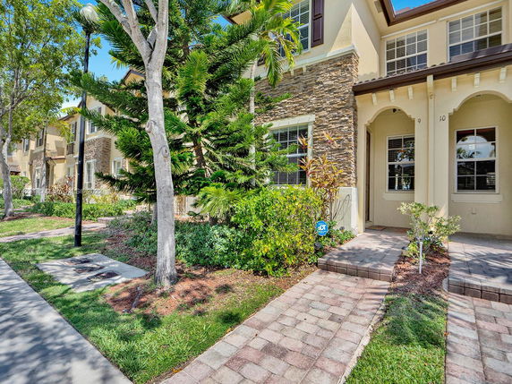 Front view of a multi-story townhouse with stone and stucco exterior.