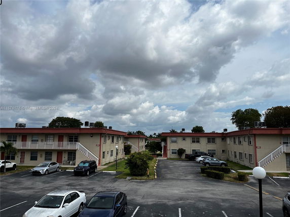 View of apartment buildings with a parking area.