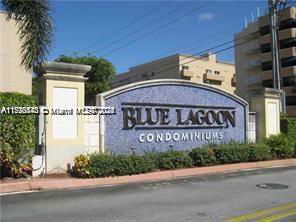 Front view of Blue Lagoon Condominiums sign with buildings in the background.
