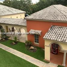 Front view of a building with an arched walkway and tiled roof.
