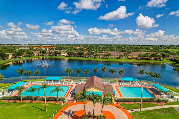 Panoramic view of a residential area with a lake and swimming pools.