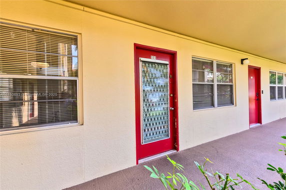 Exterior view of a building with red doors and windows.