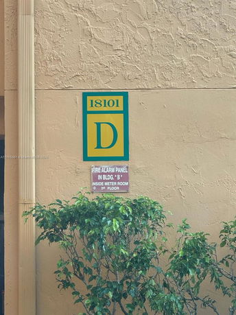 Exterior wall of a building with signage displaying '18101 D' and information about the fire alarm panel.
