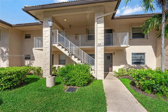 Front view of a two-story residential building with an exterior staircase.