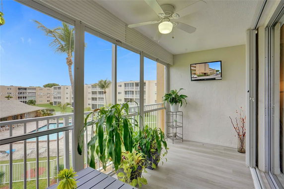 View from a balcony overlooking apartment buildings and a swimming pool.