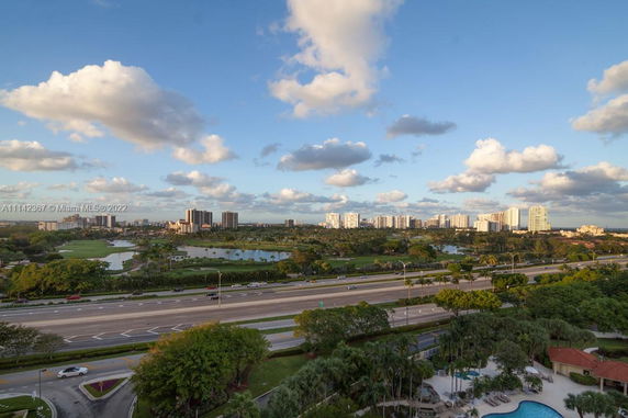 Panoramic view of a cityscape with highways, buildings, and greenery.