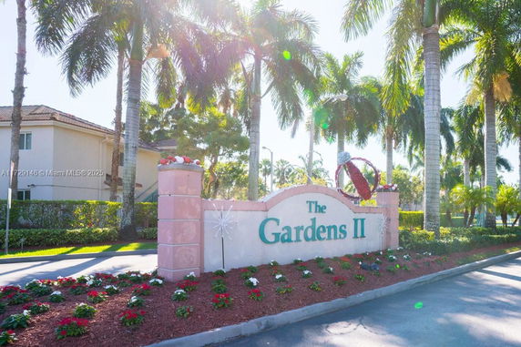 Entrance view of a residential area with a sign reading 'The Gardens II'.