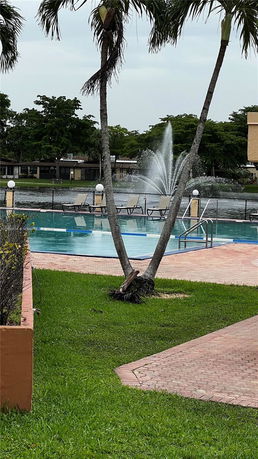 Outdoor swimming pool area with a waterfall feature.