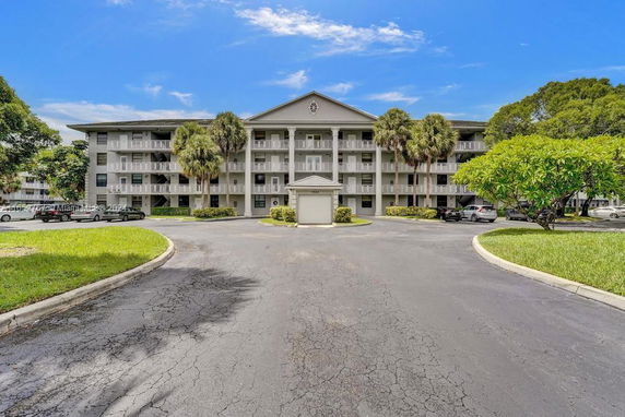 Front view of a multi-story residential building with a circular driveway.