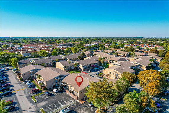 Aerial view of a residential community with multiple similar buildings and parking areas.