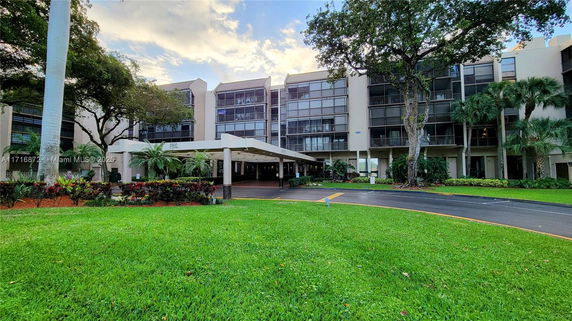 Front view of a multi-story residential building with a covered entrance.