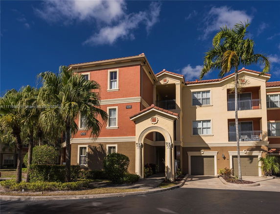 Front view of a three-story residential building with balconies.