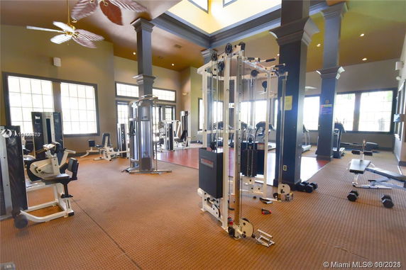 Indoor gym area with exercise equipment and large windows.