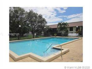 Outdoor swimming pool in a residential area with surrounding greenery.