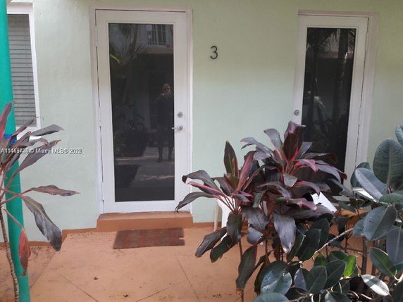 Front view of a building entrance with a glass door and number 3 on it.