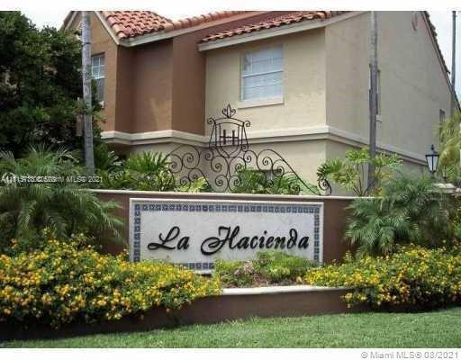 Front view of a two-story house with a decorative sign reading 'La Hacienda'.