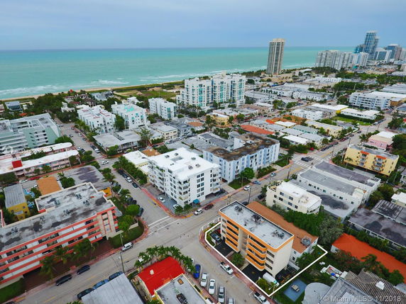 Aerial view of a coastal city with numerous residential buildings and the ocean in the background.