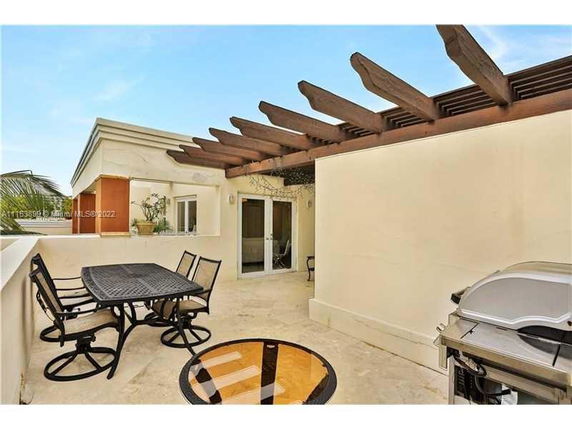 Rooftop area with pergola and outdoor furniture.
