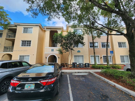 Front view of a three-story building with multiple windows and an arched entrance.