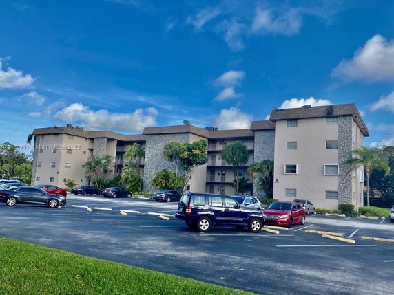 Front view of a multi-story residential building with parking spaces.