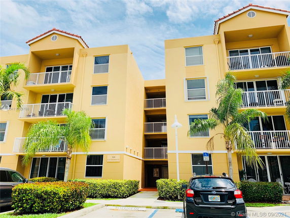 Front view of a multi-story apartment building with balconies.