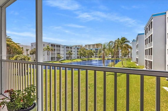 View from a balcony overlooking a pond and several multi-story residential buildings.