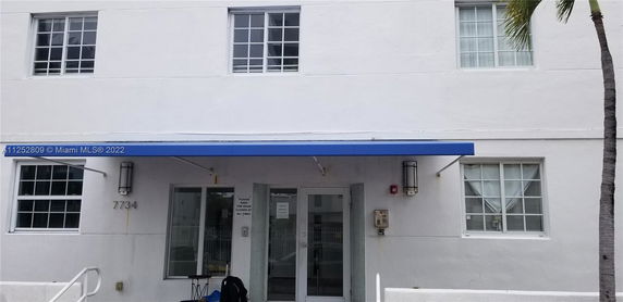 Front view of a multi-story building with a blue awning.