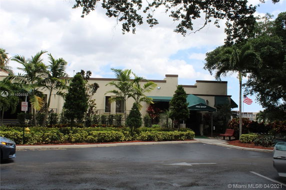 Front view of a building with a Pro Shop entrance, surrounded by trees and plants.