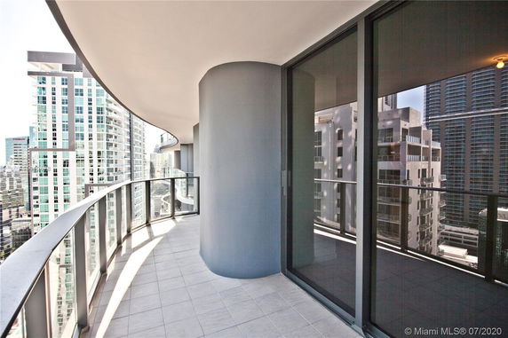 Curved balcony of a high-rise building overlooking city skyscrapers.