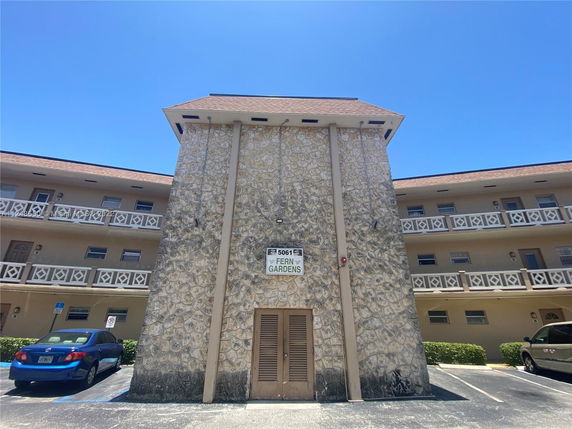 Front view of a multi-story building with stone facade and decorative railings.