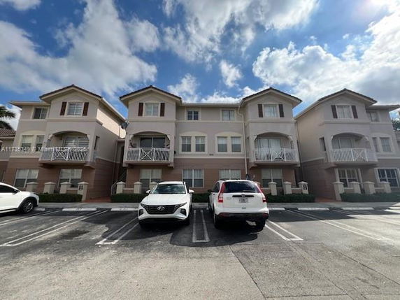 Front view of a three-story apartment building with balconies.