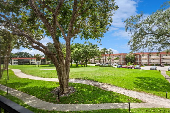 View of a building complex surrounded by green lawns and trees.