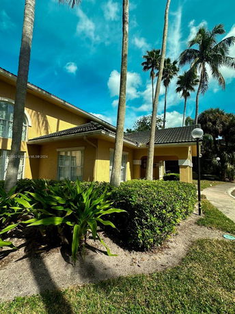 Front view of a single-story house with a yellow exterior and tiled roof.