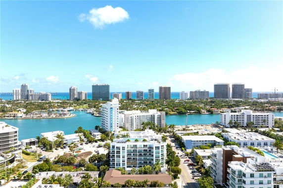 Panoramic view of a coastal cityscape with high-rise buildings and water bodies.